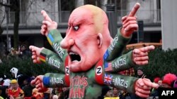 Кукла с лицето на Владимир Путин и надписи "нацисти" по ръцете се движи по време на карнавално шествие в Дюселдорф, Германия.