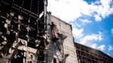 Workers clear rubble from the upper floors of a Ukrainian power plant damaged in a Russian attack on June 20.