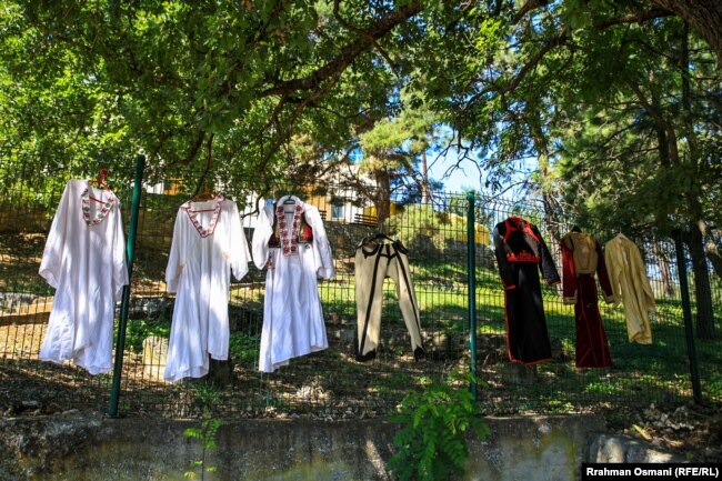 Rroba tradicionale, nga koleksioni i Ladjes, të varura në një gardh në Has, Prizren.