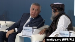 Министр торговли Казахстана Серик Жумангарин с представителем Афганистана на форуме в Астане. 3 августа 2023 года.