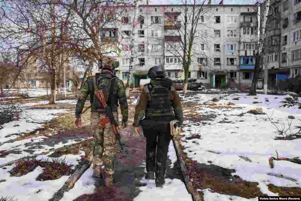 Украинский солдат и волонтёр идут к дому в Часовом Яре в надежде убедить последних остающихся в городе эвакуироваться. По оценкам, в городе живёт около 1500 человек. В основном они прячутся в подвалах. В городе нет электричества, разрушен водопровод&nbsp;