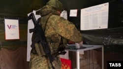 Военнослужащий РФ во время досрочного голосования на выборах президента РФ на оккупированной части Херсонской области. Украина, 10 марта 2024 года