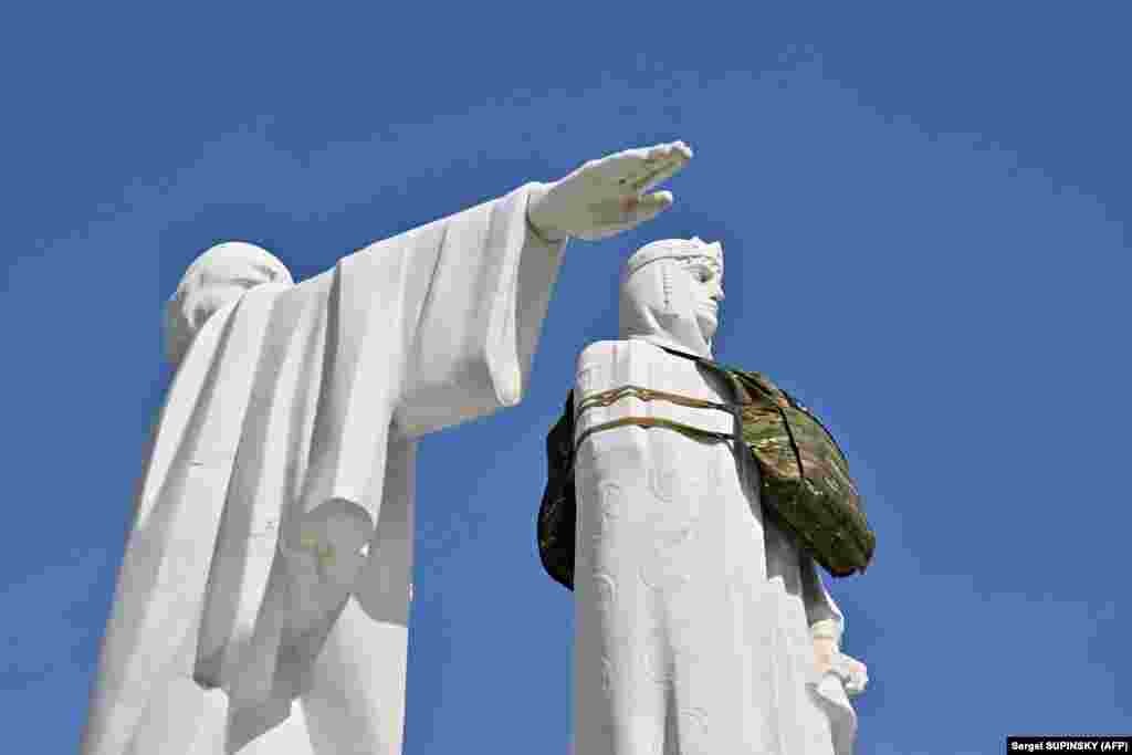 Kyiv&#39;s Princess Olha monument is dressed in a dummy bulletproof vest with a sign reading &quot;She needs armor&quot; to draw attention to the need for armor designed specifically for women amid Ukraine&#39;s war with Russia.