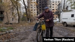 A man walks in front of damaged residential buildings in the town of Avdiyivka on October 17.