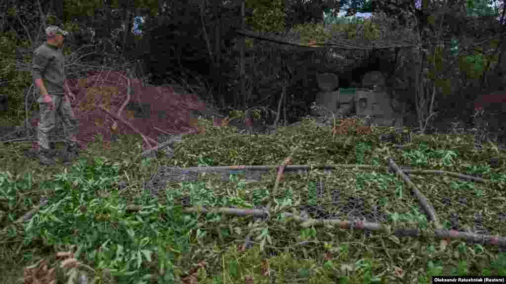 Ukrainian soldiers work to conceal a howitzer after it was used against Russian positions near Chasiv Yar. Russia captured the town in May.