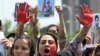 Afghan nationals carry placards in Islamabad on August 15, as they shout slogans during a demonstration against the Taliban-led government on the anniversary of the militants&#39; takeover of Afghanistan.