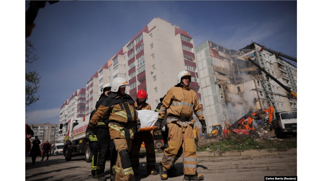 Pompierii transportă un cadavru scos din blocul avariat de atacul cu rachete rusești, în orașul Uman, regiunea Cerkasîi, Ucraina, 28 aprilie 2023.