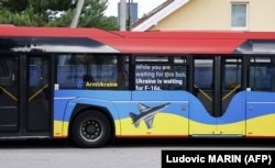 Автобус з написами «Озброюйте Україну» та «Поки ви чекаєте на цей автобус, Україна чекає на F-16» біля місця проведення саміту НАТО у столиці Литви. Вільнюсі 11 липня 2023 року
