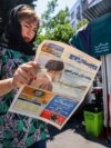 Жительница Тегерана читает газету с новостями о гибели президента