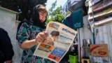 Жительница Тегерана читает газету с новостями о гибели президента
