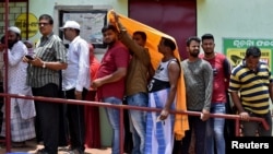 Ljudi se pokrivaju kako bi se sakrili od vrućine dok čekaju u redu ispred biračkog mjesta da daju svoje glasove tokom šeste faze opštih izbora u Indiji, vrelog ljetnog dana u Bhubaneswaru, Indija, 25. maja 2024. 