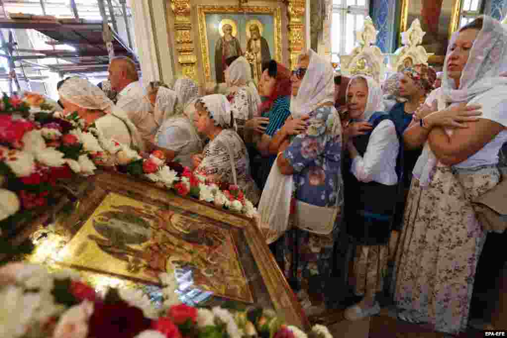 Locals and people evacuated from the Kursk region bordering Ukraine attend a service at the Assumption-Nikitsky Church in Kursk, Russia.