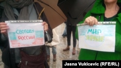 Соғысқа қарсы парақтар көтеріп тұрған адамдар. Көрнекі сурет.