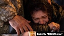 O mamă își plânge fiul căzut pe front în luptele de la Bahmut, Kiev, Ucraina, 27 martie 2023.