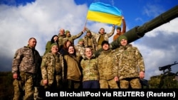 Британский міністр Бен Воллес (посередині) позує з українськими військовослужбовцями, які навчаються на військовій базі Bovington Camp на південному заході Великої Британії, 22 лютого 2023 року 