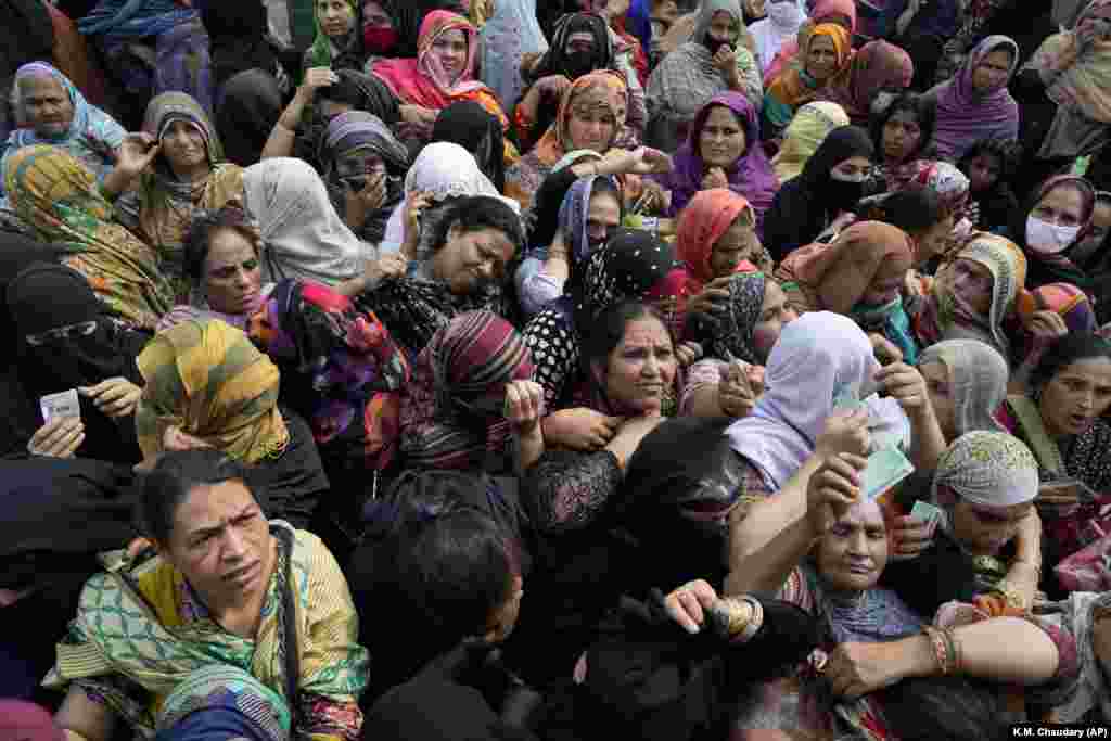 Women jostle to get a free sack of wheat flour at a distribution point in Lahore, Pakistan.&nbsp;