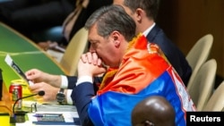 Predsednik Srbije Aleksandar Vučić ogrnut srpskom zastavom, nakon usvajanja Rezolucije o genocidu u Srebrenici na Generalnoj skupštini UN, 23. maja 2024.