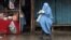 An Afghan woman in a burqa walks along a street.