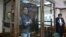 U.S. journalist Evan Gershkovich, arrested on espionage charges, stands inside a defendants' cage before a hearing to consider an appeal on his arrest at the Moscow City Court in Moscow on April 18.
