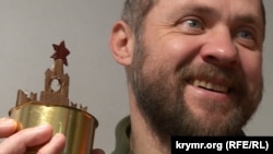 Богдан «Бома» тримає в руках окопну свічку з гнітом у формі Кремля
