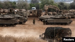Israeli tanks and militiary vehicles mass at the Israeli side of the Gaza border on October 9.