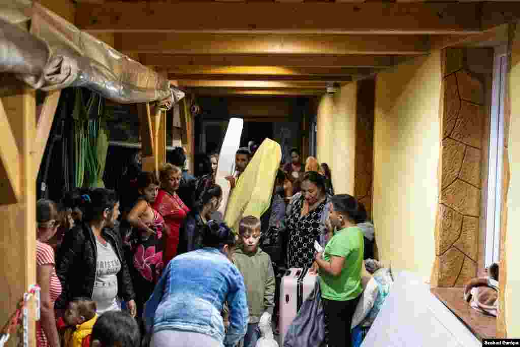 Donated mattresses are passed along as families with young children prepare to sleep for the night at the bus station. &nbsp;