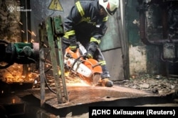 Angajat al serviciului pentru situații de urgență al Ucrainei, la locul unei lovituri militare rusești, în regiunea Kiev.