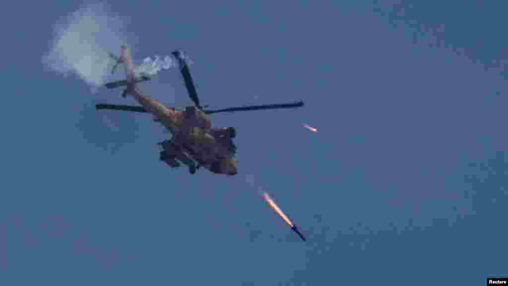 Egy izraeli katonai Apache helikopterrakétákat lő ki Gáza felé 2024. május 14-én. Az izraeli hadsereg szerint &bdquo;több terroristát is likvidáltak&rdquo;, alagútaknákat lokalizáltak, valamint kilövőállásokat és egy fegyverraktárat számoltak fel a Gázaváros keleti részén fekvő Zeitún körzetében