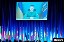 Ukrainian President Volodymyr Zelenskiy speaks via video link to the NATO Parliamentary Assembly in Copenhagen on October 9. He drew parallels between the Hamas attack on Israel and the invasion of Ukraine, calling Hamas a "terrorist organization" and Russia a "terrorist state."