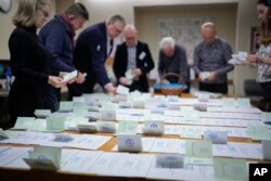 Сотрудники избирательной комиссии подсчитывают бюллетени после закрытия голосования на избирательном участке в Таллинне, 5 марта 2023 года
