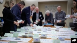 Сотрудники избирательной комиссии подсчитывают бюллетени после закрытия голосования на избирательном участке в Таллинне, Эстония, 5 марта 2023 года