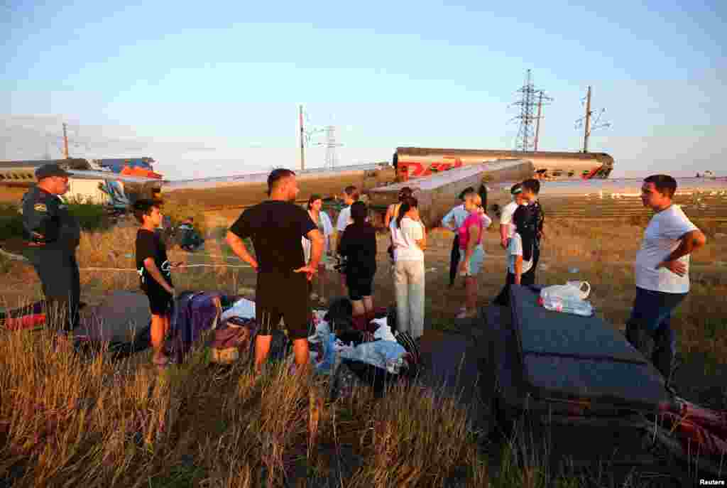  Passengers and emergency workers gather near the carriages of a train that derailed after a collision with a truck in Russia&#39;s Volgograd region. &nbsp; 