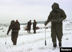 Югославские солдаты измеряют уровень радиоактивности возле южного сербского города Прешево в 2001 году после того, как военные самолёты выпустили тысячи снарядов с обеднённым ураном во время бомбардировки Югославии силами НАТО