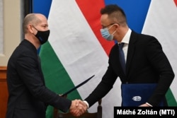 Szijjártó Péter külgazdasági és külügyminiszter (j), valamint Pallai Miklós, az Autoliv Kft. ügyvezetője kezet fog, miután aláírták a stratégiai együttműködési megállapodást a Külgazdasági és Külügyminisztériumban 2022. január 20-án