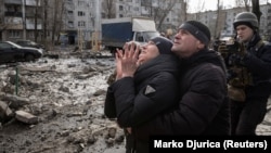 A woman reacts as her brother is rescued after an apartment block was heavily damaged by a missile strike in Pokrovsk in Ukraine's Donetsk region on February 15.