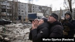 Реакцията на жена, чийто брат е спасен, след като жилищен блок беше ударен от руска ракета в град Покровск в Донецка област в Украйна на 15 февруари 2023 г.