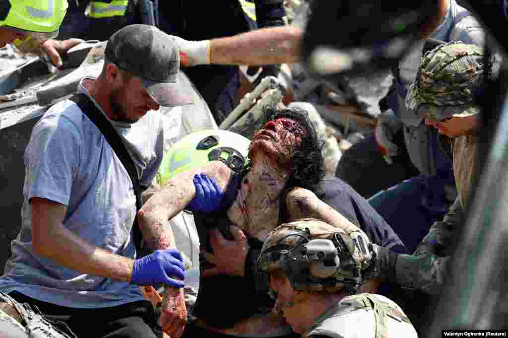 Rescuers remove an injured woman from the rubble.