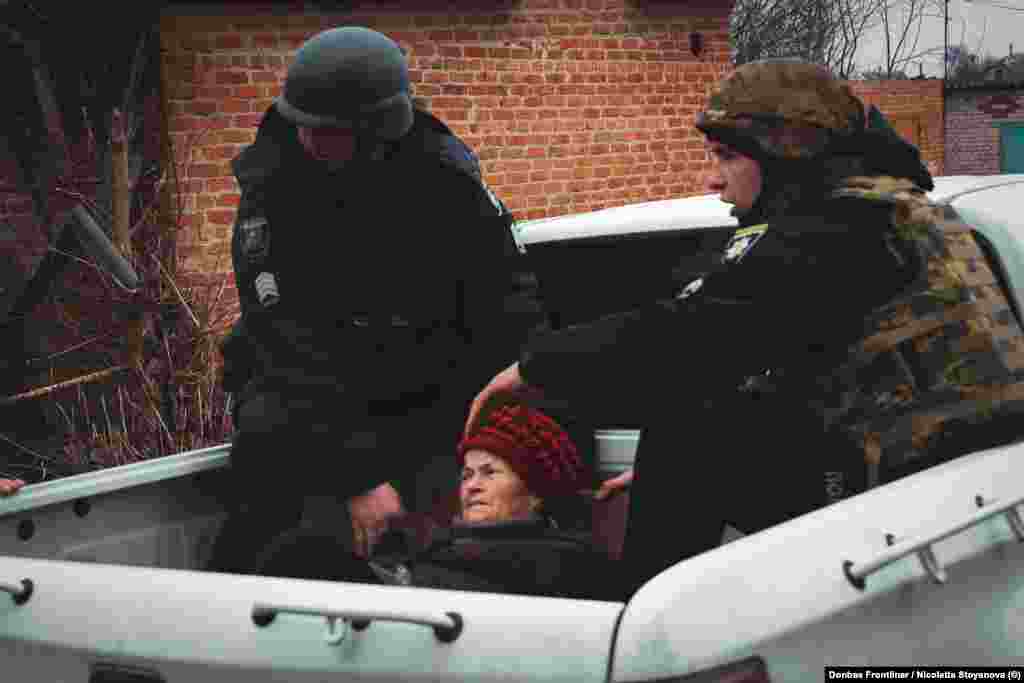 Войници утешават възрастна жена, докато я евакуират от дома ѝ във Велика Писаривка, Сумска област, в Североизточна Украйна. Датата е 18 март. Украинските власти извеждат хората от града, който се намира само на 7 км от границата с Русия. &nbsp;