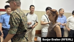 Journalist Aike Beishekeeva (right) from the Temirov Live investigative group is escorted to a Bishkek courtroom on June 7. 