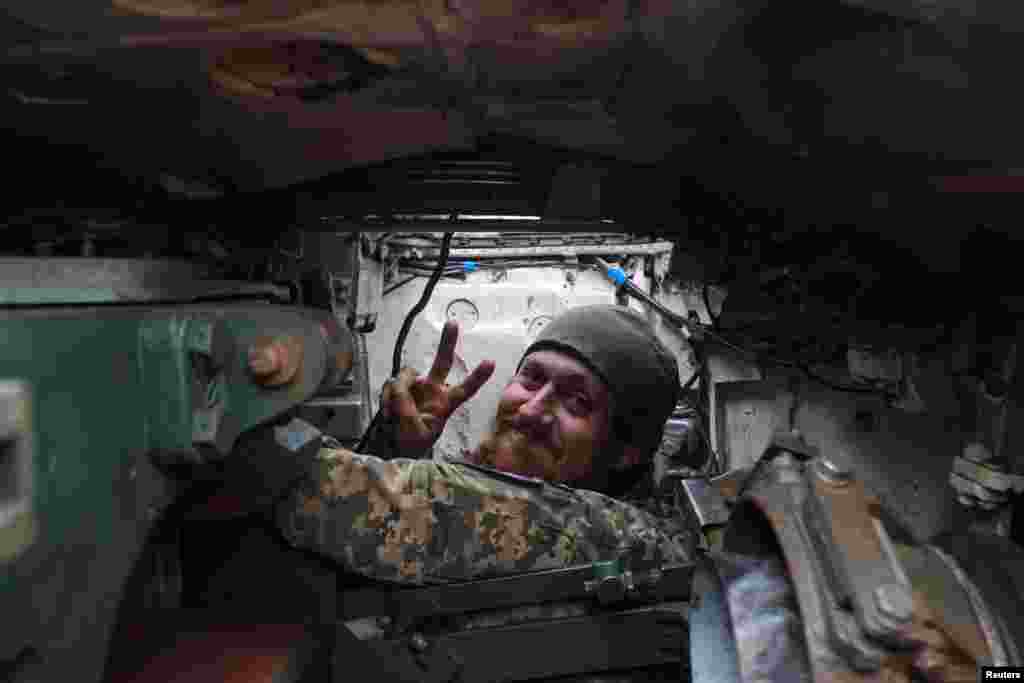 Ukrainian serviceman shows a victory sign inside a tank near the frontline town of Bakhmut
