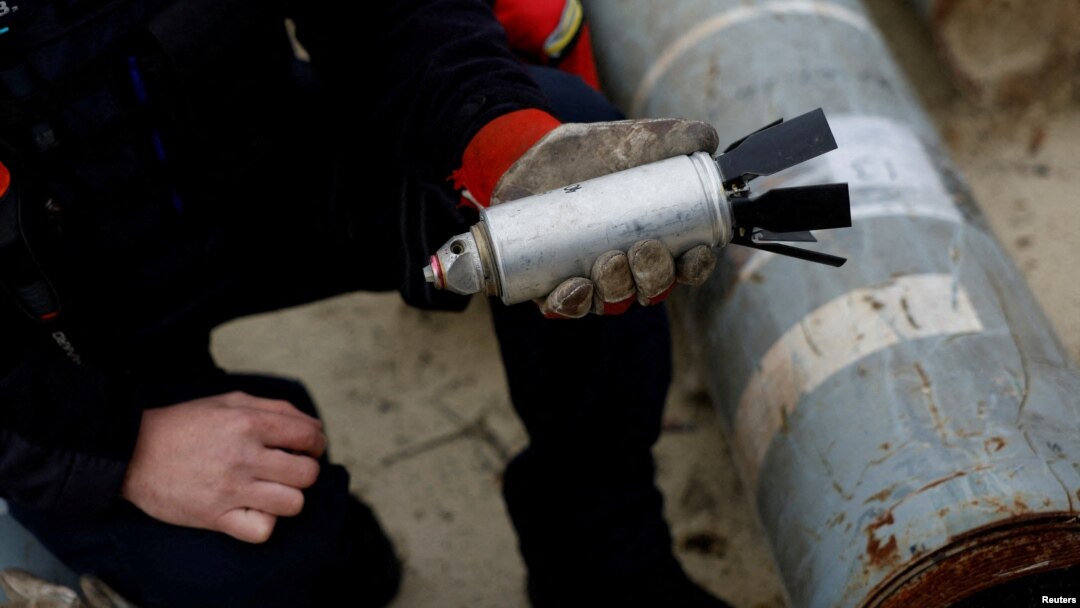 A Ukrainian soldier holds a defused cluster bomb from an MSLR missile in Kharkiv on October 21, 2022.