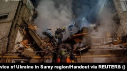 Rescuers work at the site of an apartment building heavily damaged by a Russian drone strike in Sumy, Ukraine, on March 13.