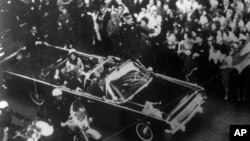 Presidenti amerikan John F. Kennedy dhe gruaja e tij duke kaluar nëpër qendrën e Dallasit më 1963, disa momente para se të vritej. 