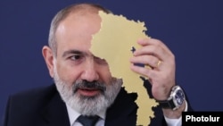 Armenia - Prime Minister Nikol Pashinian holds a cardboard cutout of Armenia's map at a news conference in Yerevan, March 12, 2024,