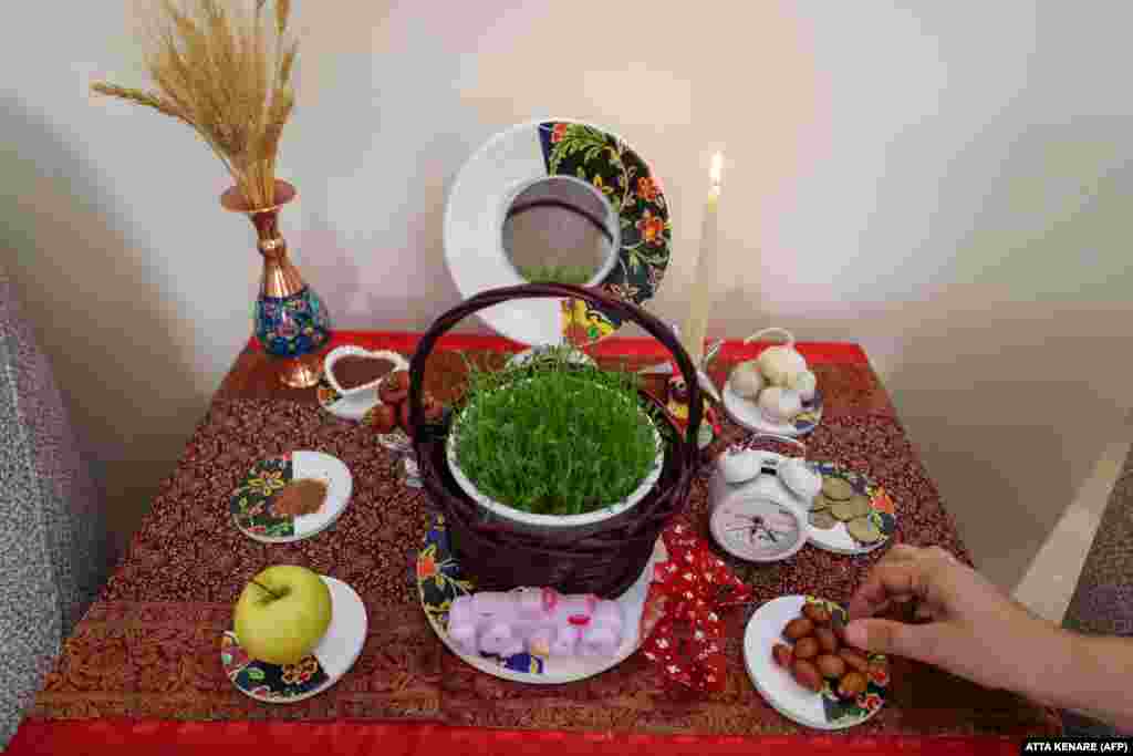 An Iranian decorates a table with Haft-Sin in Tehran in preparation for Norouz, the Persian New Year.