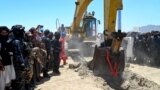 Taliban security personnel surround an excavator at work during an inauguration ceremony of the Mes Aynak copper-mining project on July 24.