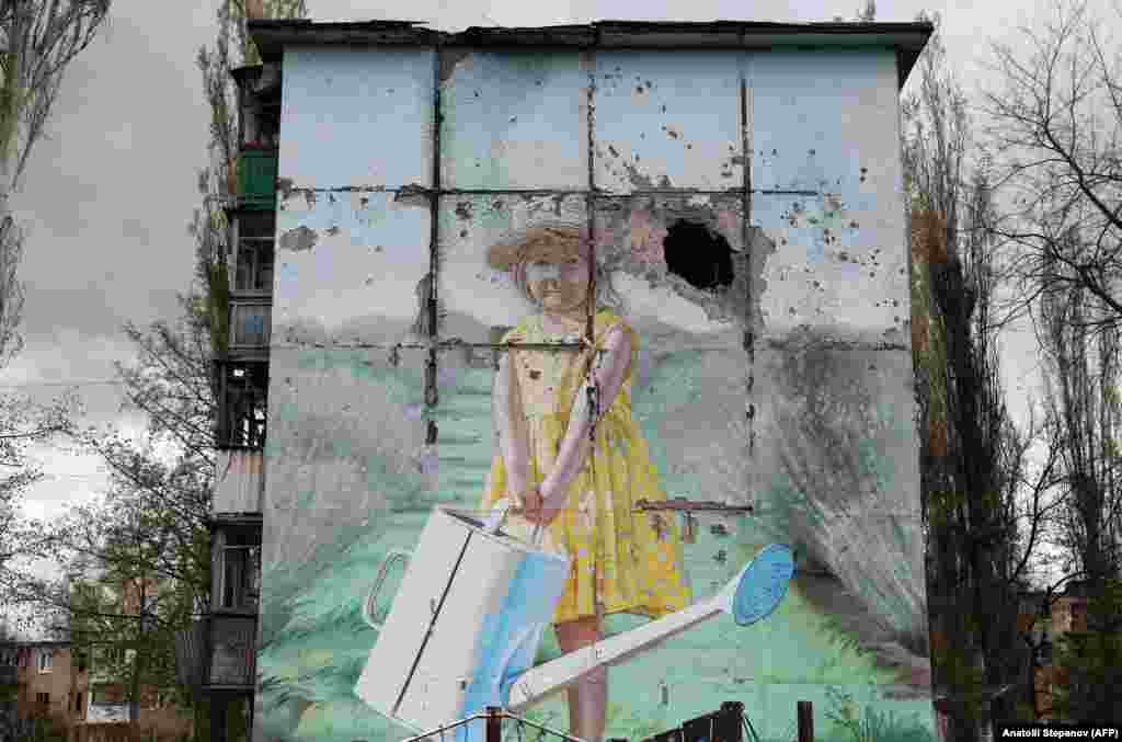 Mural na teško oštećenoj stambenoj zgradi u ukrajinskom gradu Avdijevki na prvoj liniji fronta usred sveobuhvatne ruske invazije na Ukrajinu. &nbsp;