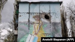 Мурал на пошкодженому російськими обстрілами будинку в Авдіївці на Донеччині, квітень, 2023 року