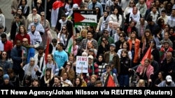 Demonstranti drže palestinske zastave i natpise tokom demonstracija "Stop Izraelu", protiv učešća Izraela na Eurosongu zbog njegove ofanzive u Gazi protiv Hamasa, u Malmeu, Švedska, 11. maja 2024. 