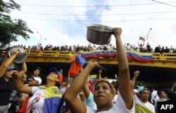 Un bărbat lovește într-o cratiță în timpul unui protest împotriva guvernului președintelui venezuelean Nicolas Maduro în Valencia, statul Carabobo, pe 29 iulie 2024, la o zi după alegerile prezidențiale din Venezuela.